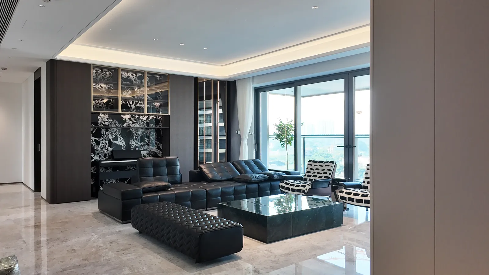 Living room of the Guangzhou Residence with dark wood wall panels and glass display cabinetry
